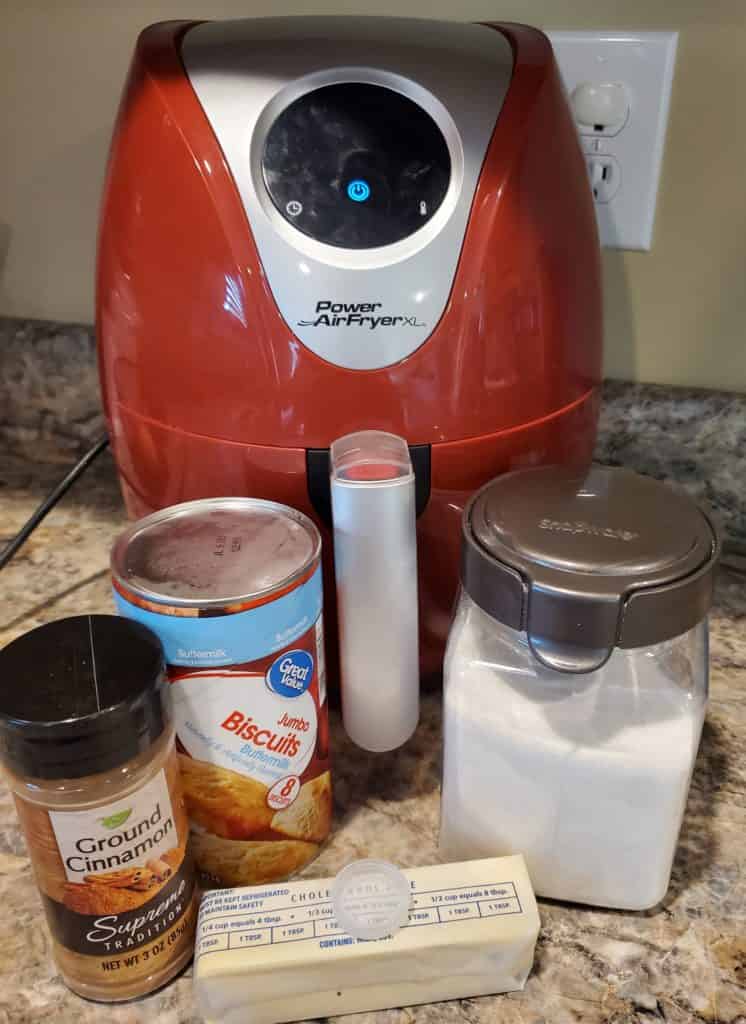 Ingredients for the air fryer doughnuts recipe: Air fryer, canned biscuits, ground cinnamon, sugar and butter