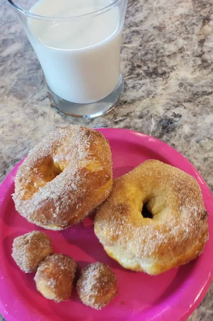 Air fry doughnuts on a plate with a glass of ice cold milk
