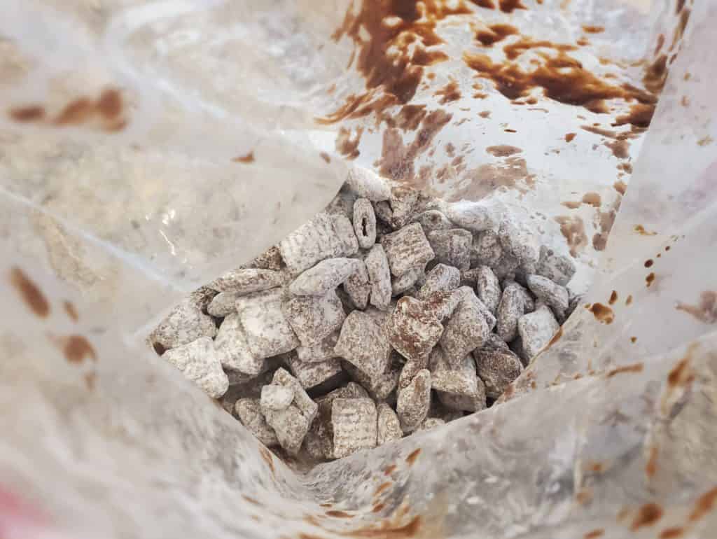 The puppy chow covered in powdered sugar in the bag