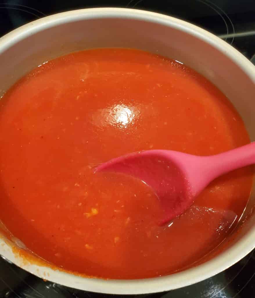 The creamy tomato soup cooking on the stovetop