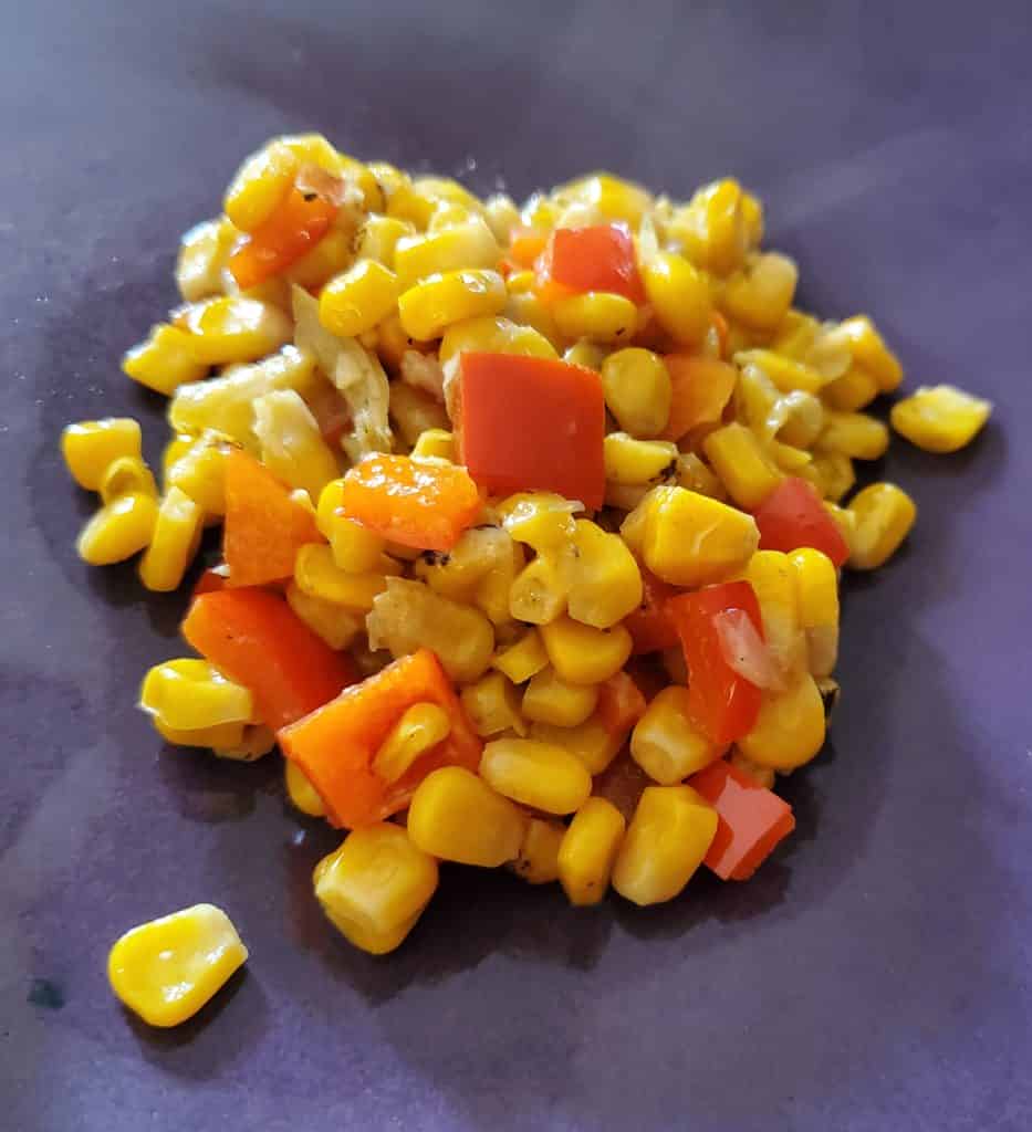 Fire-roasted corn and red peppers on a plate