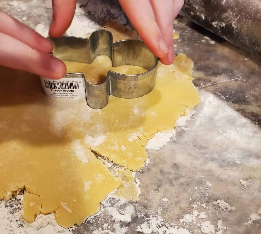 Using a cookie cutter to make sugar cookie cutouts