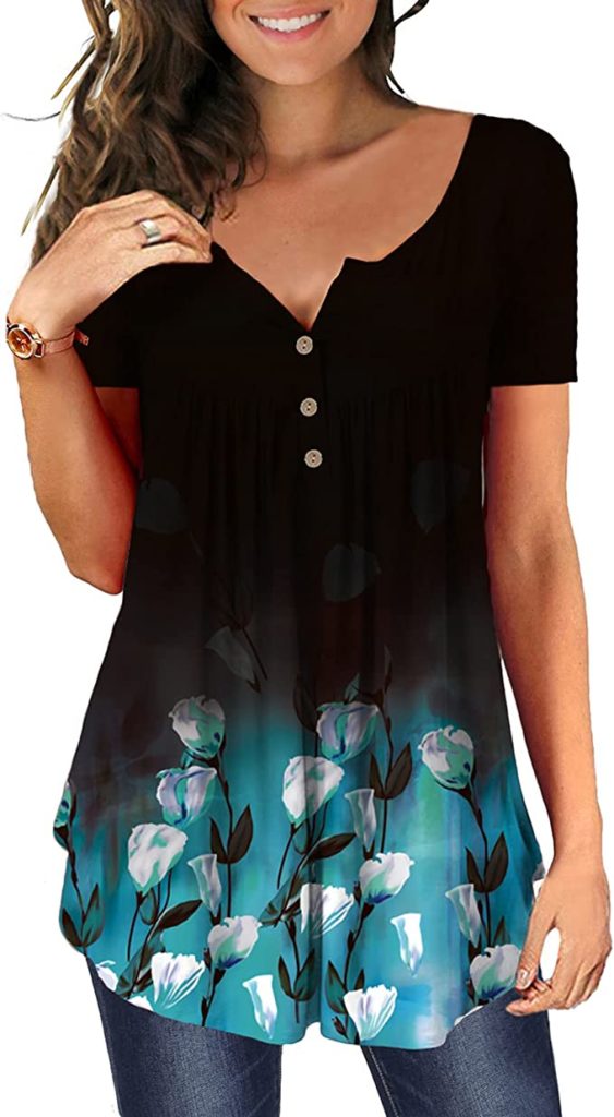 This tunic top for moms is a henley style with three buttons on the collar. It is shown in black with a blue floral pattern around the bottom third.