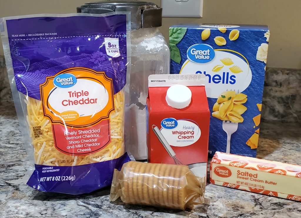 Baked mac and cheese with Ritz cracker topping ingredients: triple cheddar shredded cheese, heavy whipping cream, flour, pasta shells, butter and Ritz crackers