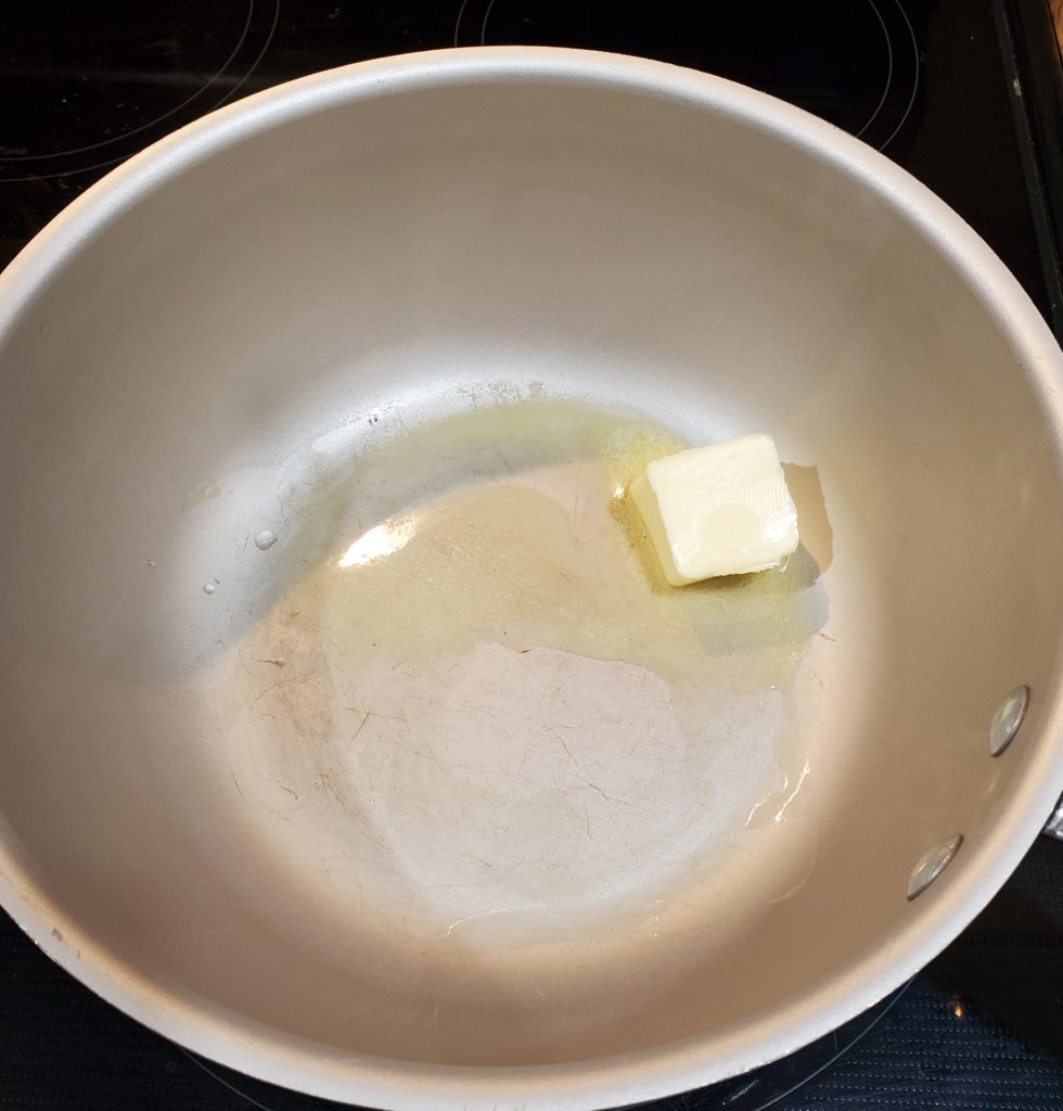 Butter for the baked mac and cheese with Ritz cracker topping melting in a medium saucepan over medium/high heat