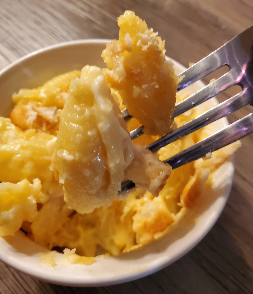 A forkful of the finished baked mac and cheese with Ritz cracker topping