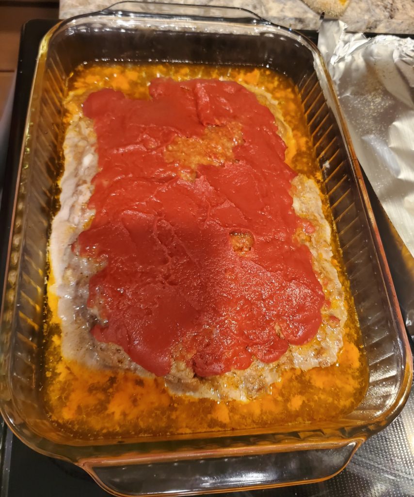 The meatloaf after having baked covered for 45 minutes with the grease around the edges