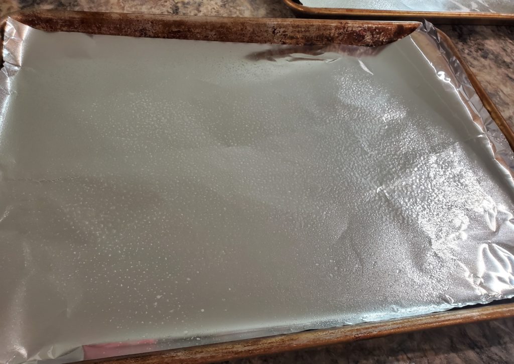 A baking sheet with sides that has been lined with aluminum foil and spritzed very lightly with non-stick cooking spray