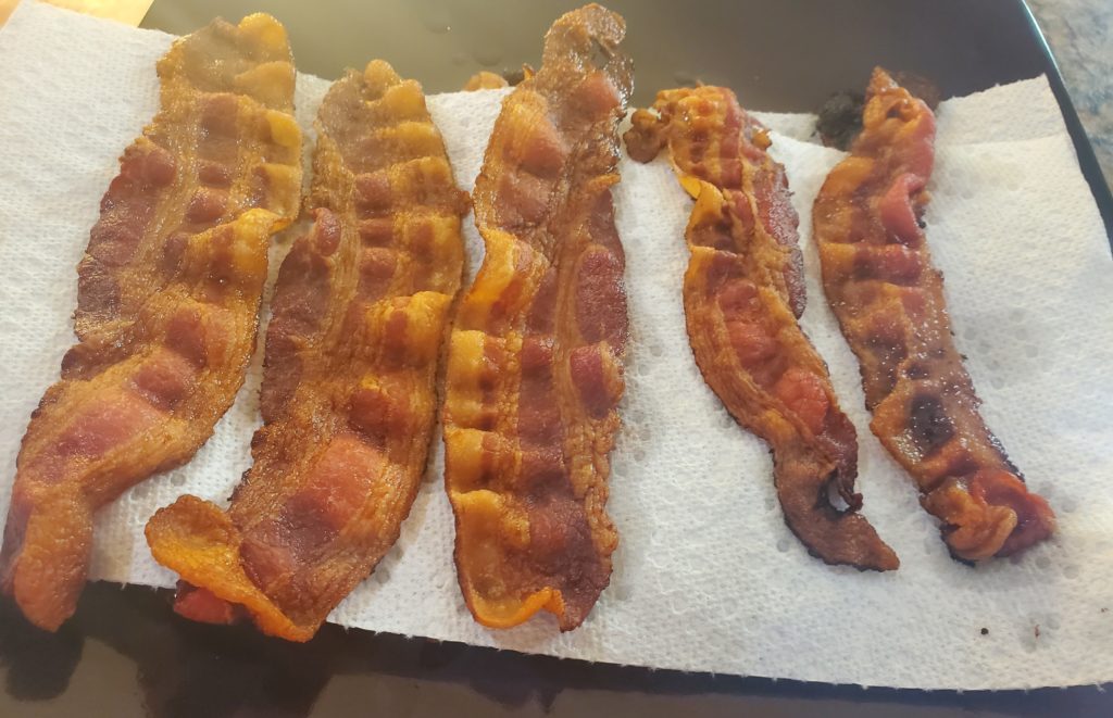 Cooked bacon on a paper towel-lined plate