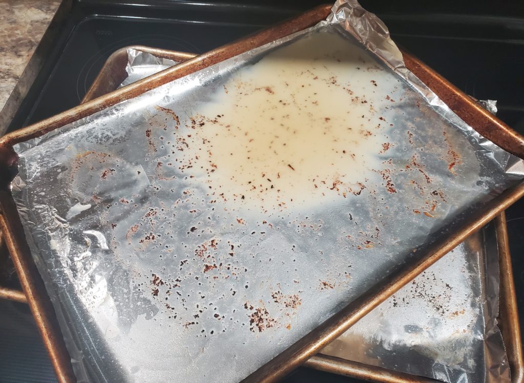 The baking sheets with solidified grease ready to be thrown away