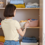 How to keep your family organized cover photo of a woman putting away items in baskets inside of a closet