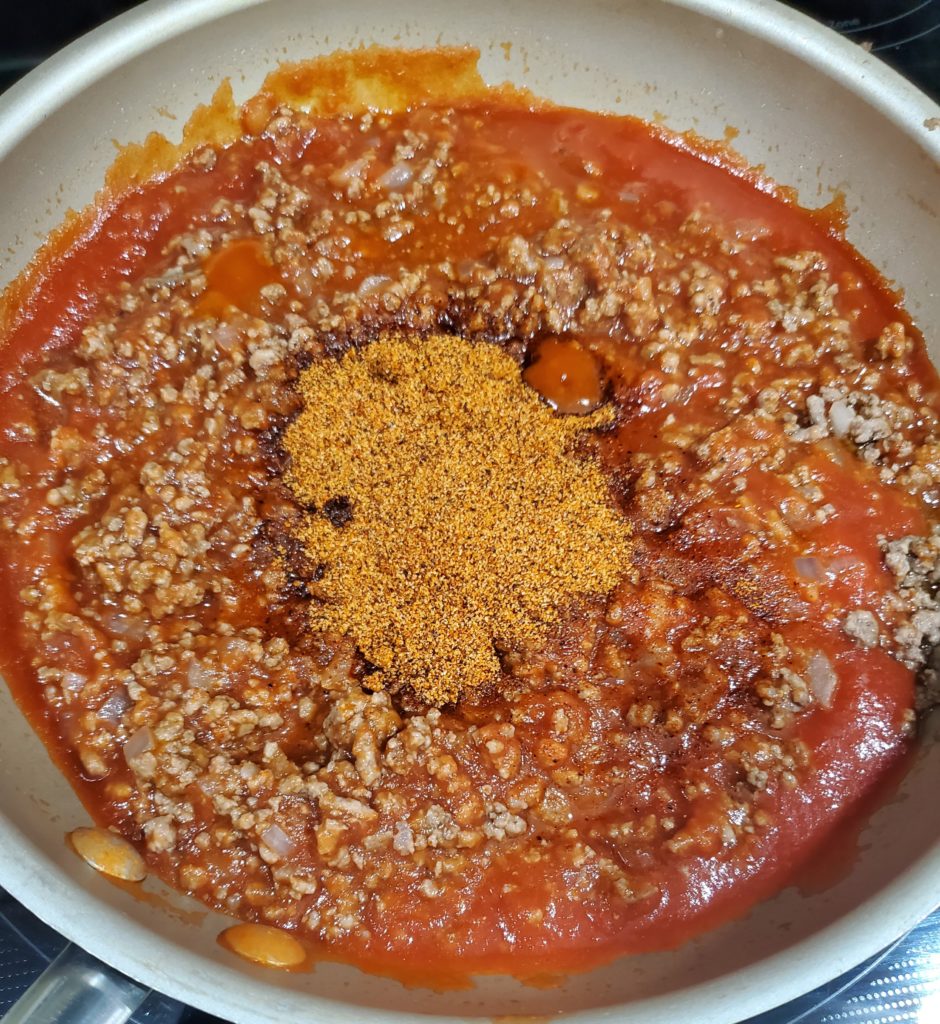 The sloppy joe recipe with the seasoning on top before being stirred in