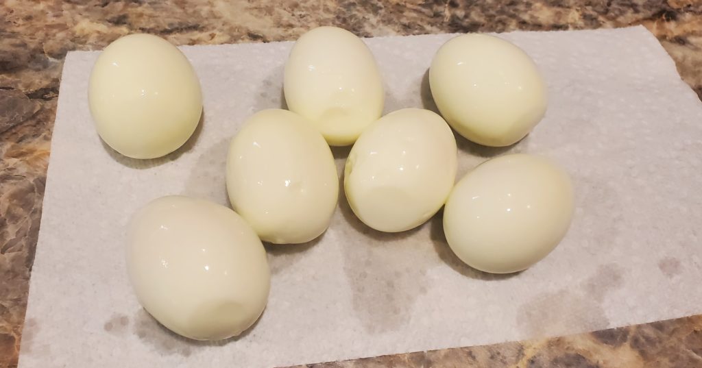 Boiled and peeled eggs drying on a paper towel to be used in this deviled eggs recipe