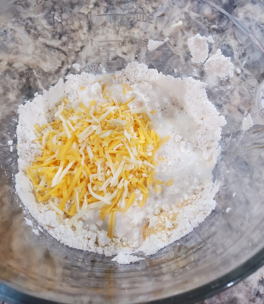 The buttered mix with shredded cheese, milk and garlic powder in it