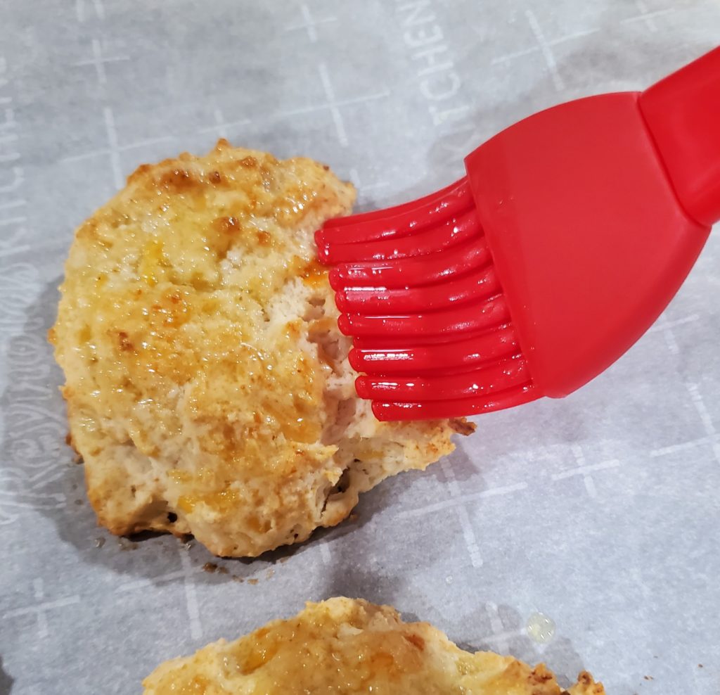 Brushing the garlic cheddar biscuits with garlic butter