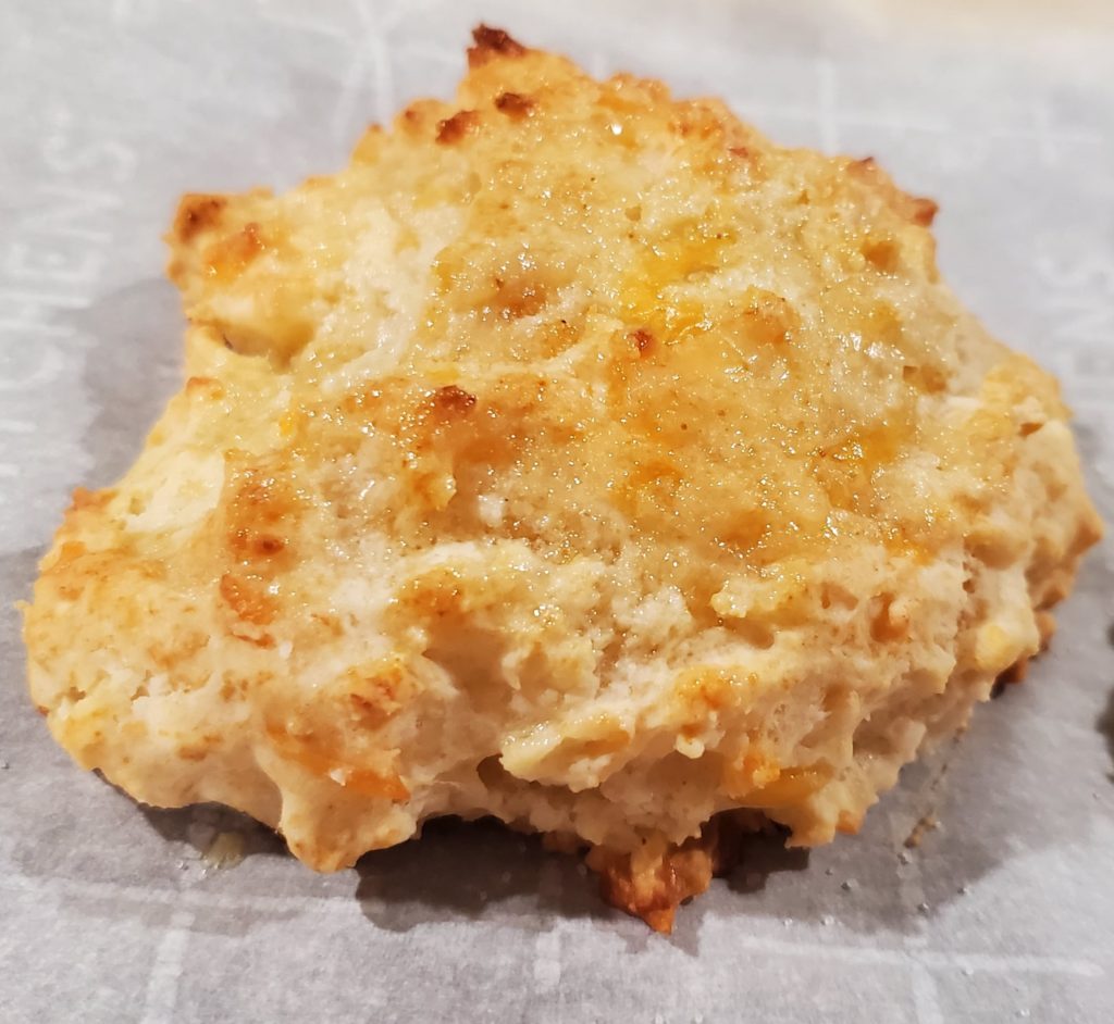 A finished garlic cheddar biscuit ready to be devoured