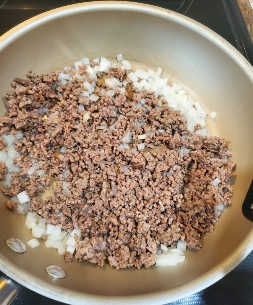 Browned ground beef in a skillet with onion