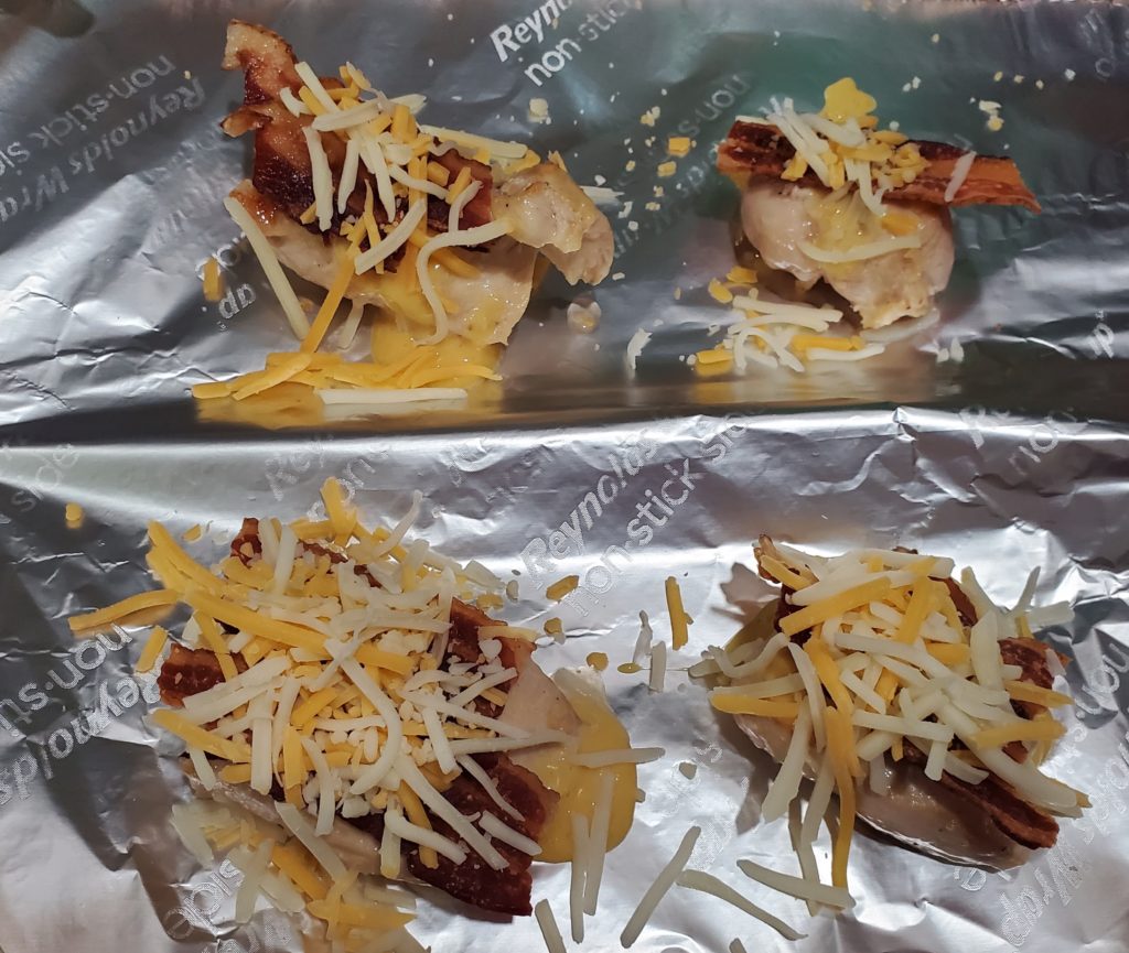 Honey mustard chicken topped with bacon and shredded cheese ready to go into the oven
