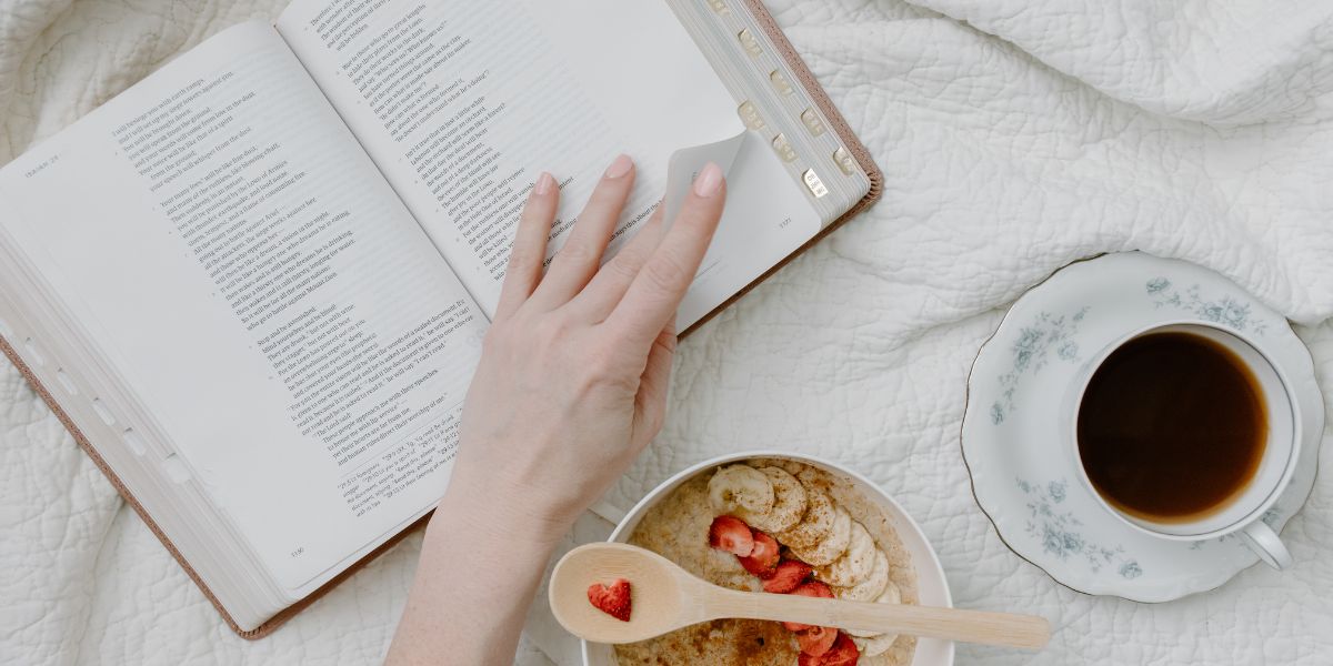 Free Bible reading plans for moms cover image of a women reading a Bible with a bowl of oatmeal and cup of coffee