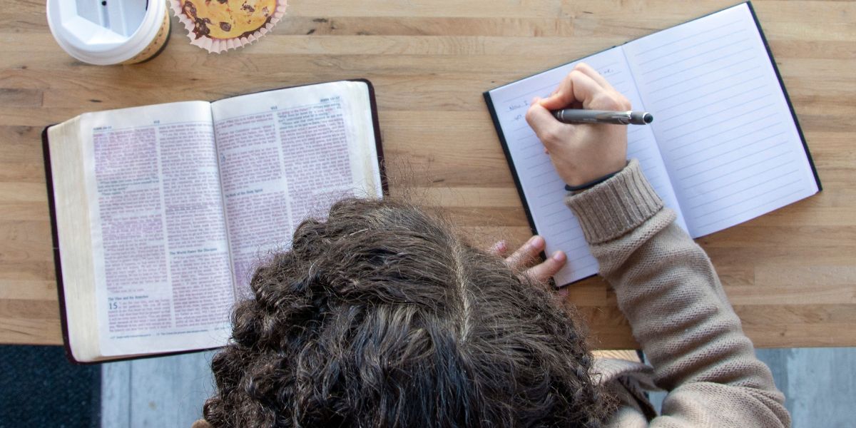 A women studying the Bible with a cup of coffee and a muffin